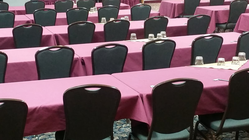 Rows of tables and chairs in hotel conference room
