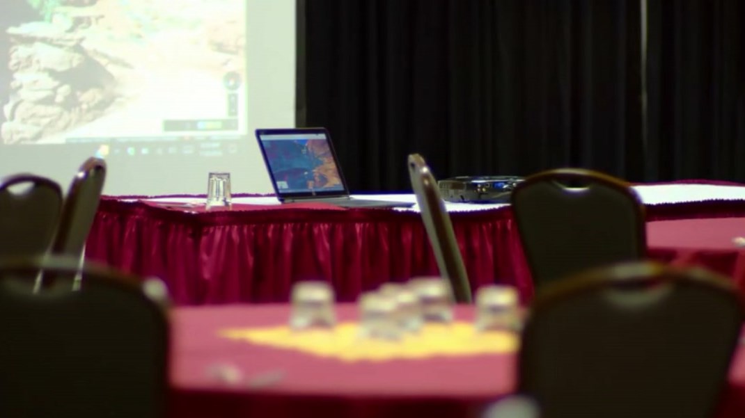 A laptop connects to a projector in a hotel conference room